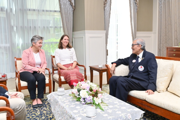 ภาพผู้ชายใส่สูทรกำลังนั่งพูดคุยกับผู้หญิง 2 คน