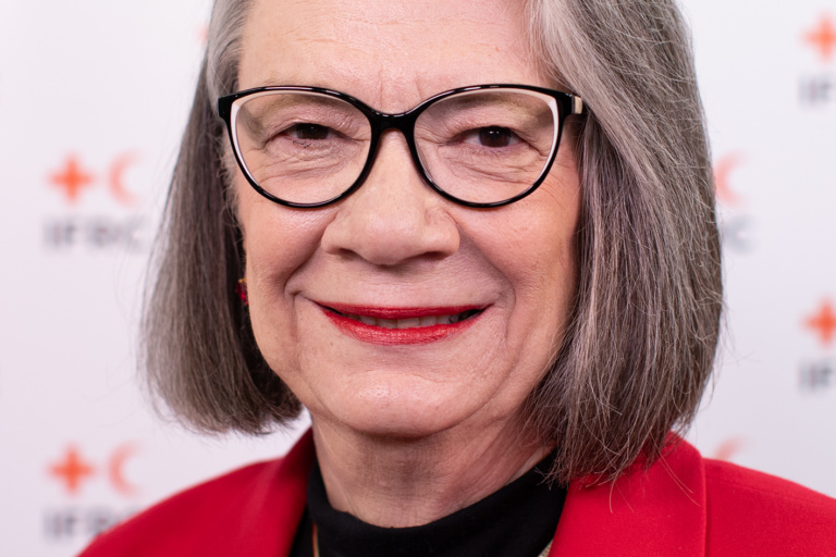 ภาพผู้หญิงใส่แวนกับชุดสูทรสีแดง