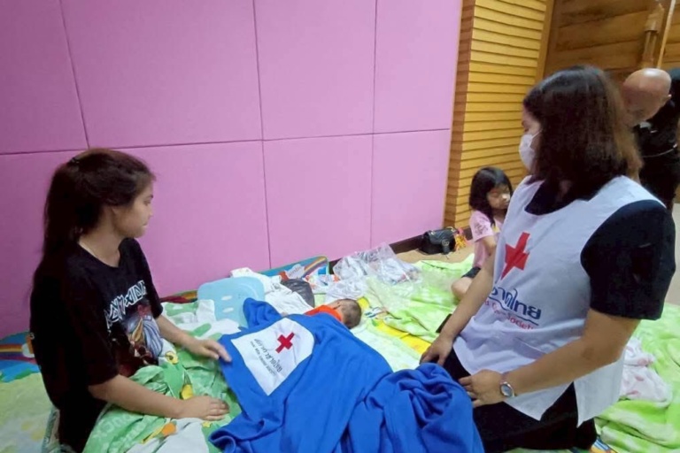 รูปภาพ เจ้าหน้าที่และผู้ประสบอุทกภัยดูแลเด็กทารก