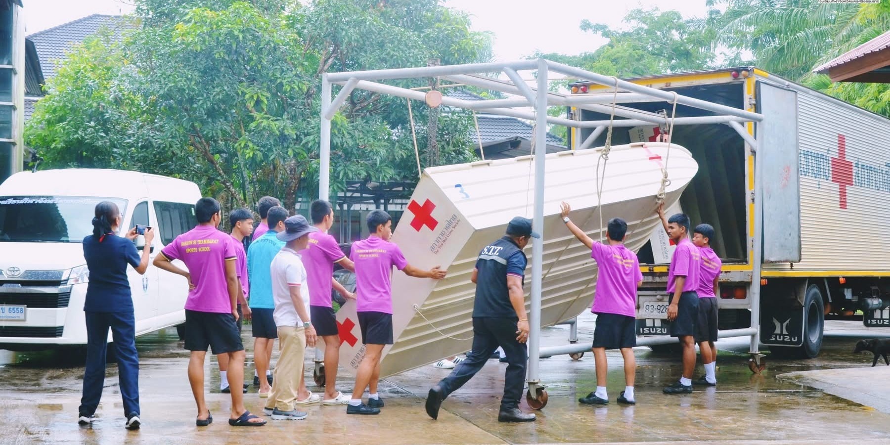 รูปภาพ เจ้าหน้าที่และนักเรียนเคลื่อนย้ายเรือท้องแบนขึ้นรถบรรทุก