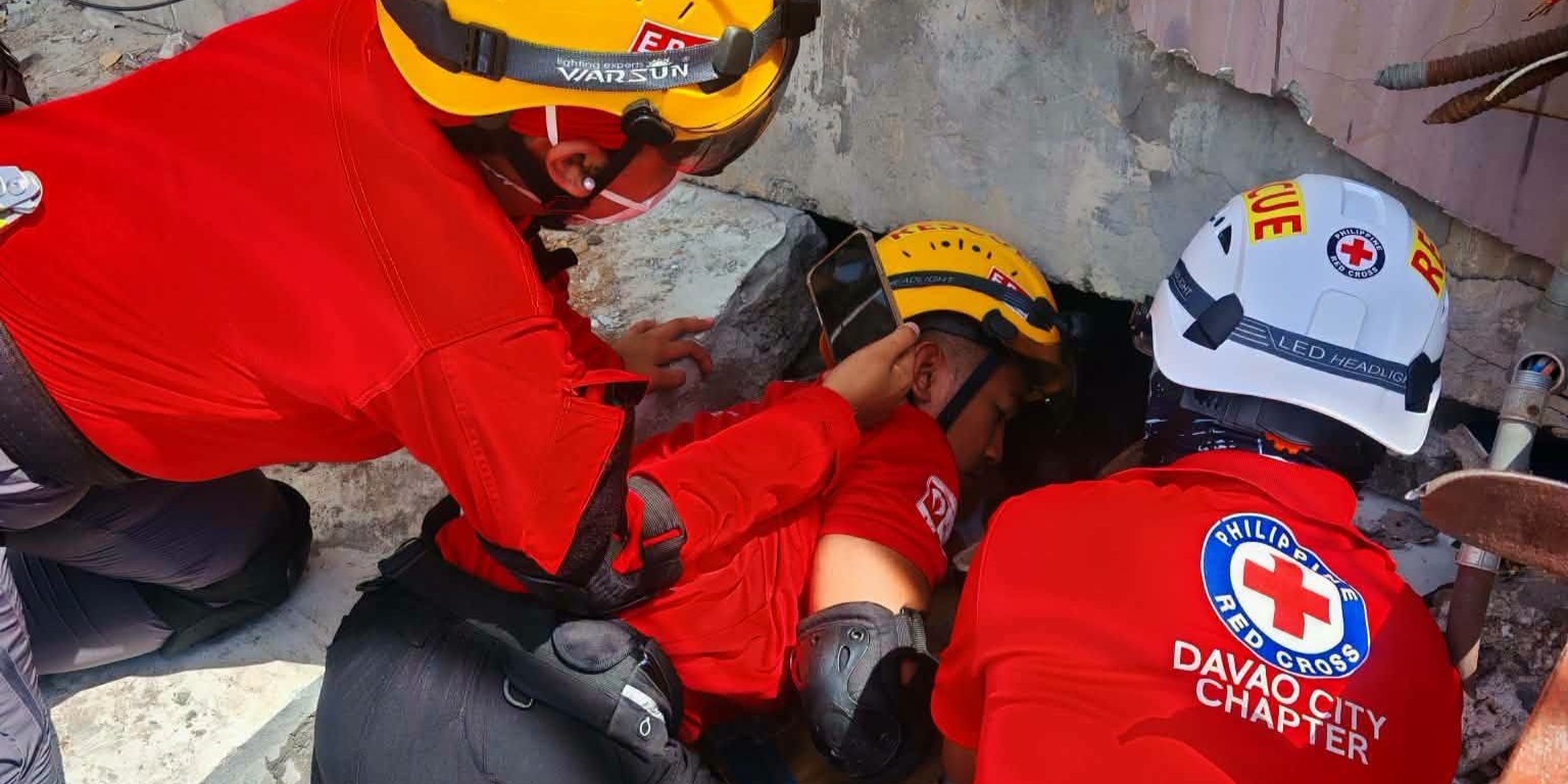 รูปที่ 2 เจ้าหน้าที่สภากาชาดฟิลิปปินกำลังค้นหาผู้สูญหายภายใต้อาคารถล่ม
